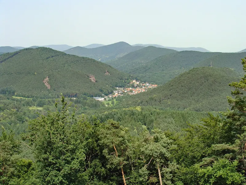 Waldige Hügel und ein Dorf im Pfälzerwald, gesehen vom Hühnerstein